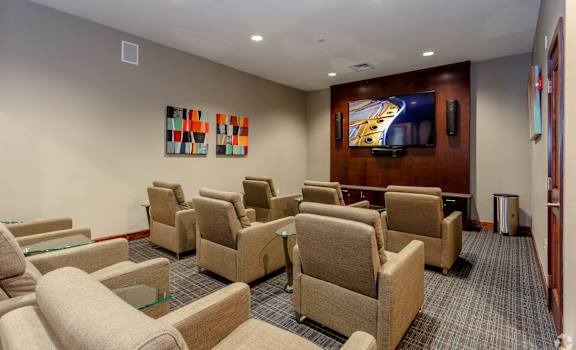 A room with a row of chairs and a television on the wall.