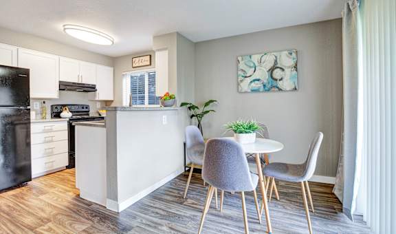 A kitchen with a table and chairs.