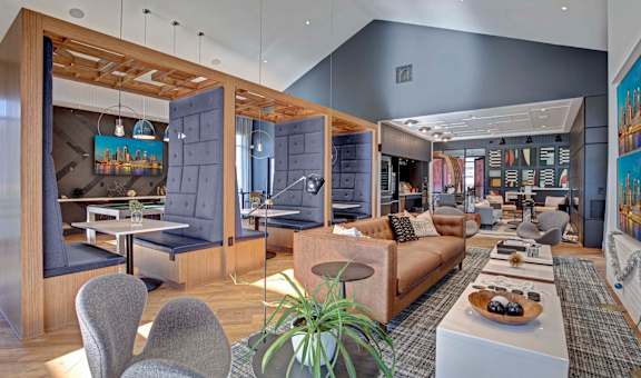 A modern living room with a grey couch and a wooden table.