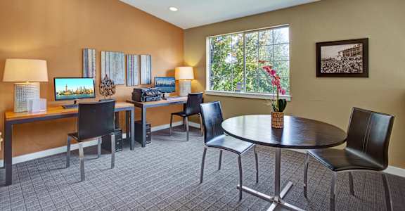 A conference room with a table, chairs, and a vase of flowers.