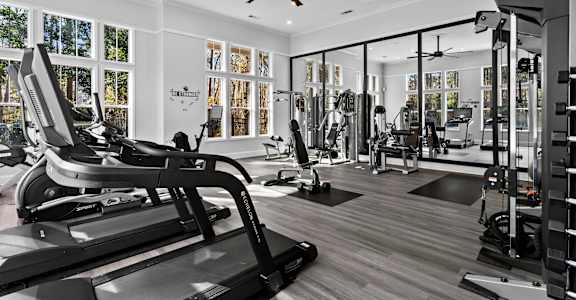 A gym with treadmills, weights, and exercise equipment.