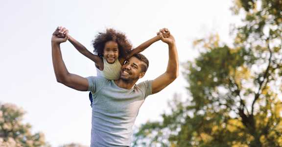 a man carrying a young girl on his shoulders