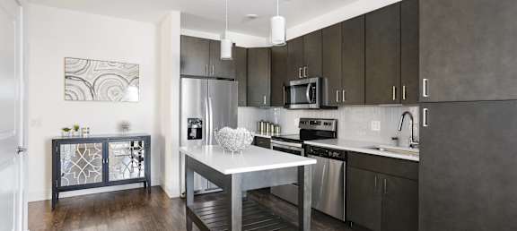 a kitchen with stainless steel appliances and a white island in the middle