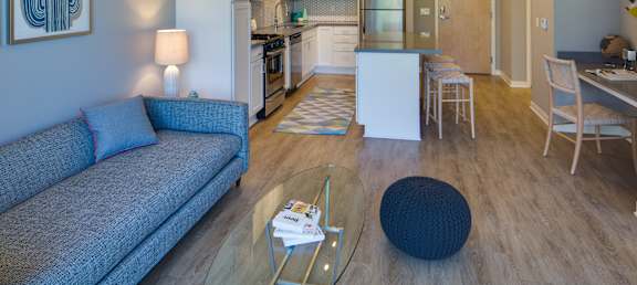 a living room and kitchen with a couch and a table
