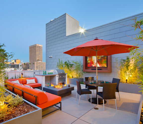 a terrace with a table and chairs and a fire pit on the side of a building