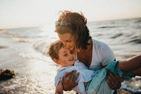 a mother holding her son on the beach