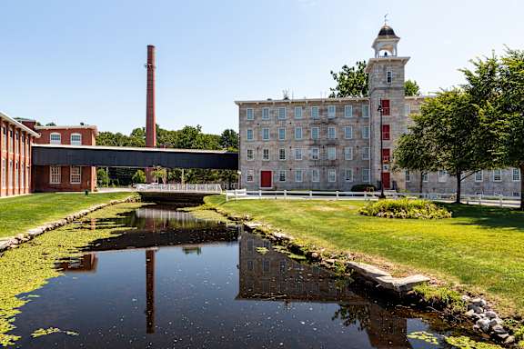 an old brick building with a river in front of it