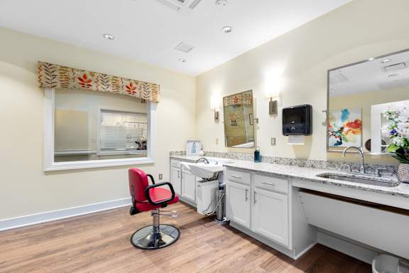 a bathroom with a sink and a mirror and a chair