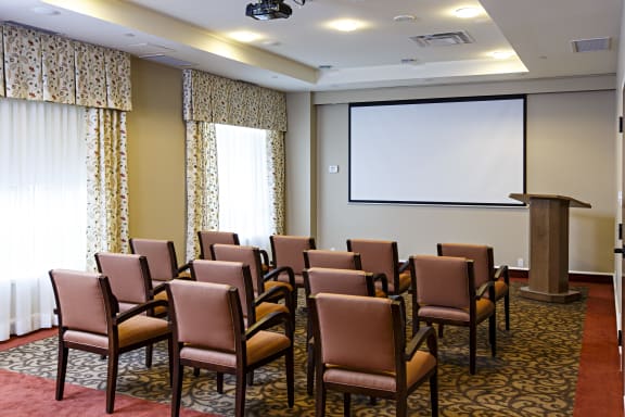 A room with chairs and a podium in front of a screen