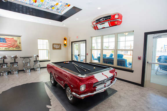 A red and white classic car is on display in a showroom.