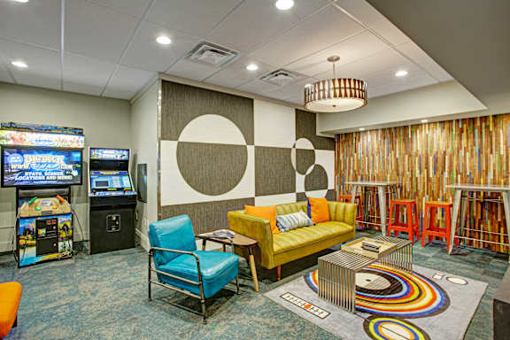 a living room with couches and chairs and a video game room