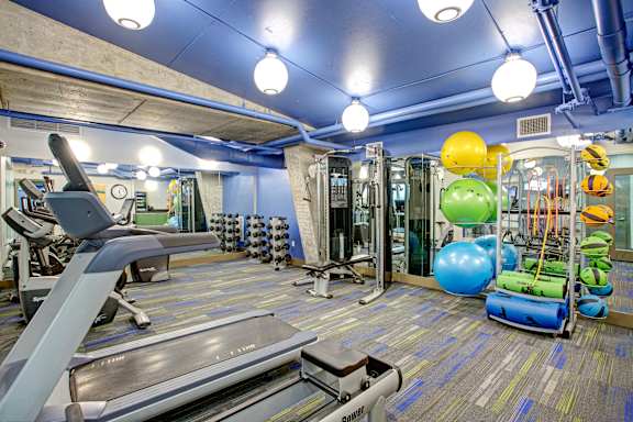 a gym with a treadmill and weights and balloons
