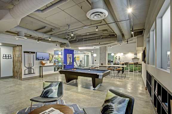 a game room with a pool table and chairs