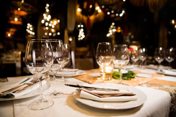 a restaurant table with wine glasses and plates and napkins