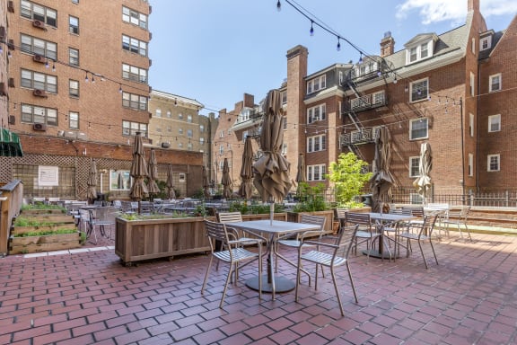 a rendering of a patio with tables and chairs in a courtyard