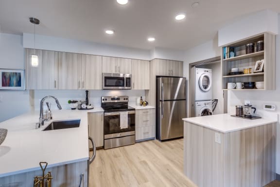 a modern kitchen with stainless steel appliances and white countertops