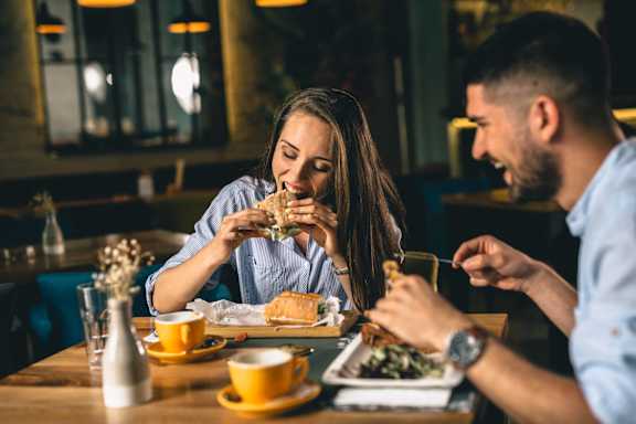 A man and a woman are enjoying a meal together in a restaurant.