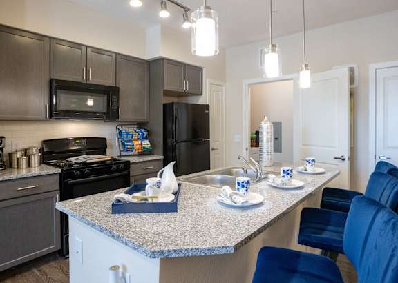 a kitchen with white cabinets and a granite counter top