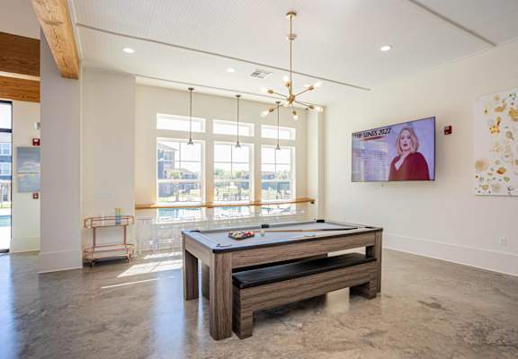 a game room with a pool table and a tv