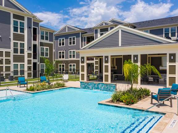 a swimming pool with an apartment building in the background