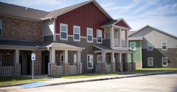 A row of houses with a blue sign in front of them.