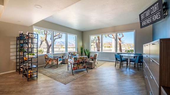 A living room with a couch, chairs, and a dining table with a view of the outdoors.