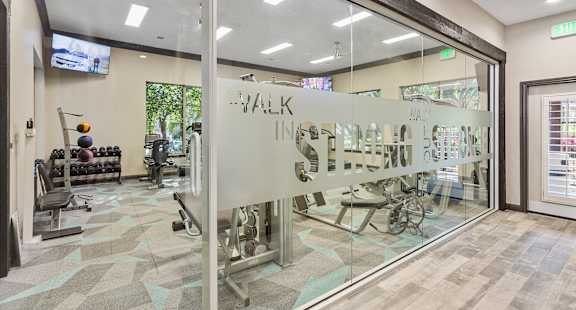 A gym with a glass wall and a sign that says "walk in".