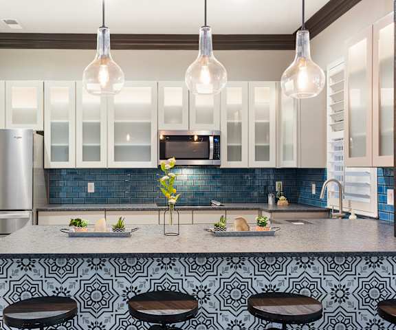 a kitchen with white cabinets and a counter top with blue tiles at Sonterra Apartment Homes, Texas, 78726