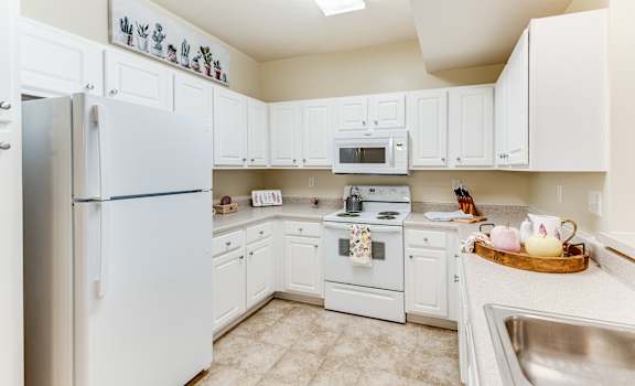 a white kitchen with white appliances and white cabinets