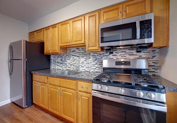 Kitchen with wooden cabinetry at Garwood Gardens Apartments, Garwood