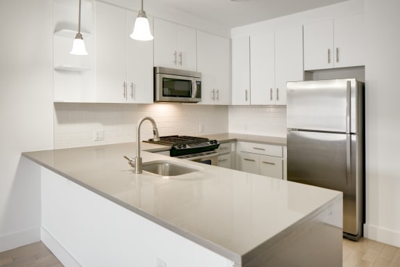 a kitchen with white cabinets and stainless steel appliances