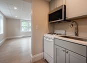 Thumbnail 2 of 7 - A kitchen with a white oven and microwave.