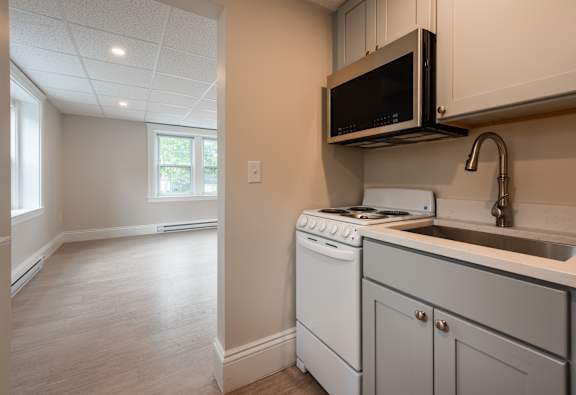 A kitchen with a white oven and microwave.