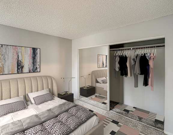 A bedroom with a large bed and a wardrobe with clothes hanging on it.