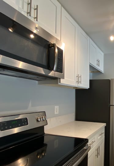 A kitchen with a stove top oven and microwave above it.