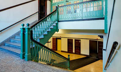 A staircase with a green railing and steps. at Chapman House, E. Boston, Massachusetts