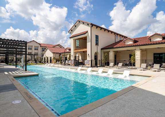 A large house with a red tile roof and a stone facade. at Northwoods, Texas, 77388
