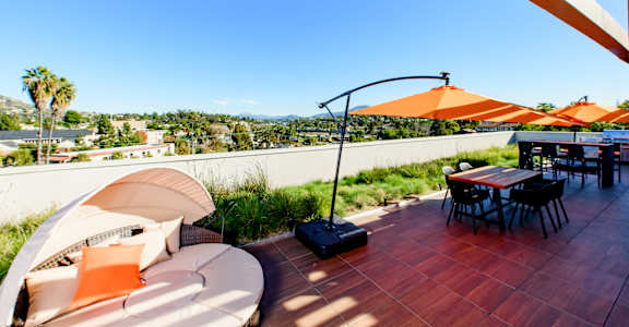 A patio with a table and chairs overlooking a cityscape.