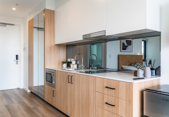 a kitchen with wooden cabinetry and a white counter top