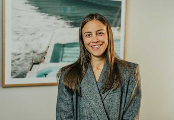 a woman with long hair standing in front of a painting