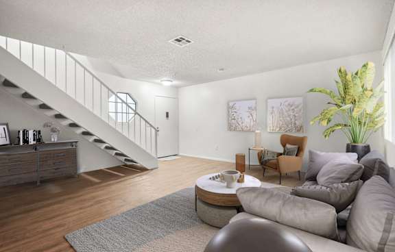 A modern living room with a grey rug and a grey sofa.