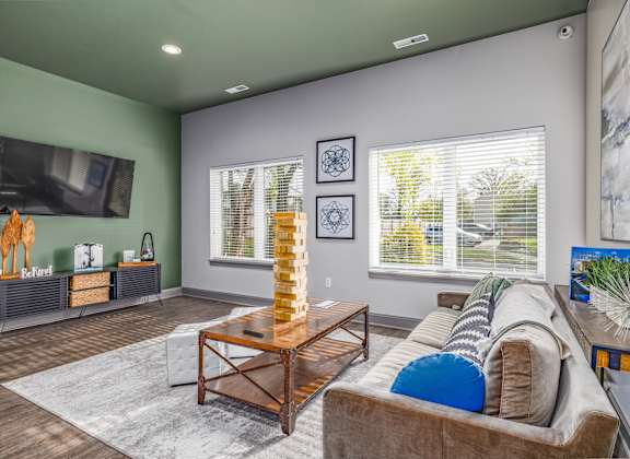 A living room with a couch, a coffee table, and a television.