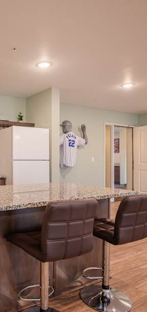 A kitchen with a bar area and two chairs.