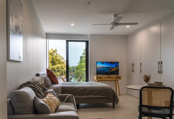 a bedroom with a couch and a bed and a television