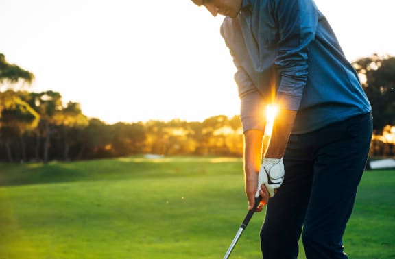 a man holding a golf club on a golf course