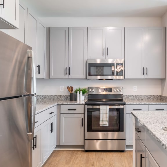 a kitchen with white cabinets and stainless steel appliances