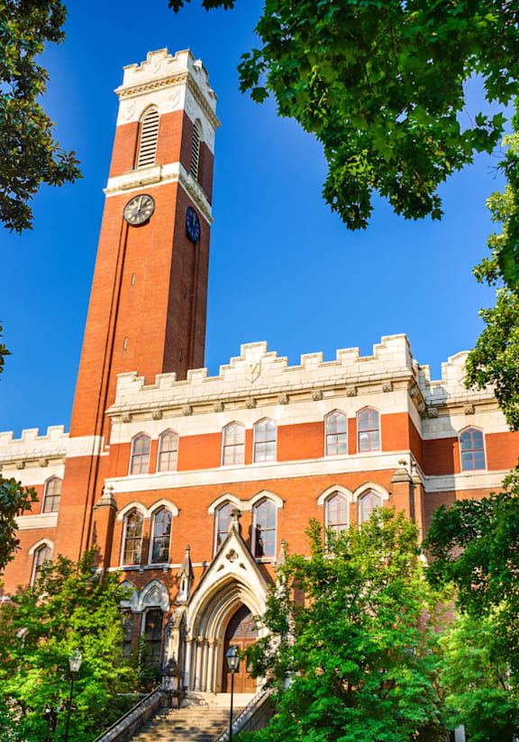 Vanderbilt red brick building with a clock tower and trees in front.