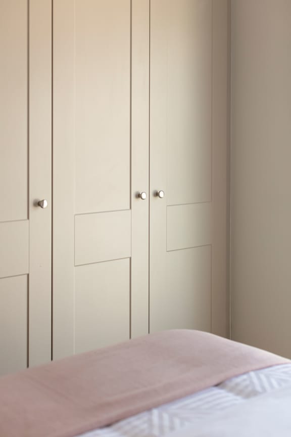 a bedroom with a bed and white closet doors