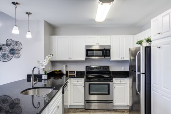 a kitchen with stainless steel appliances and white cabinets