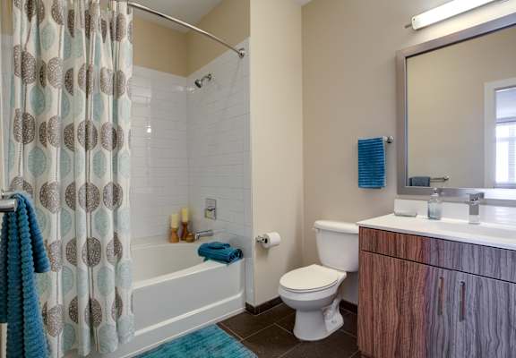 A bathroom with a toilet, sink, and shower.